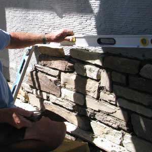 Mason applies ston to house